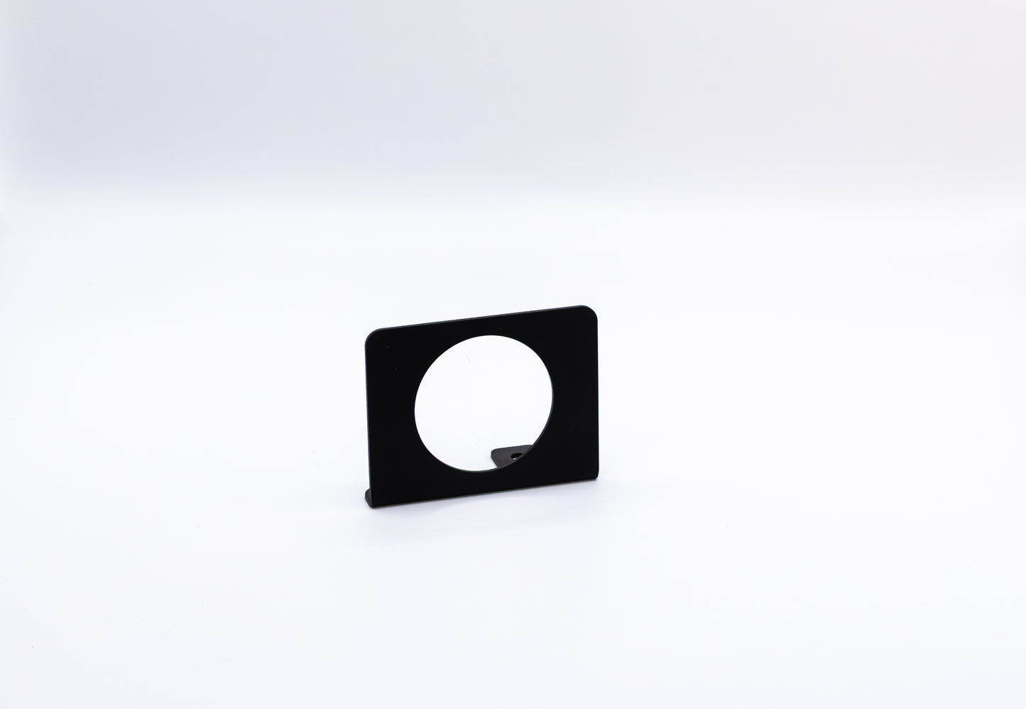 The Gauge Mount Sidekick Accessory by StayFlush Motorsports is a black, rectangular mount with a large circular cutout, shown upright against a plain white background.