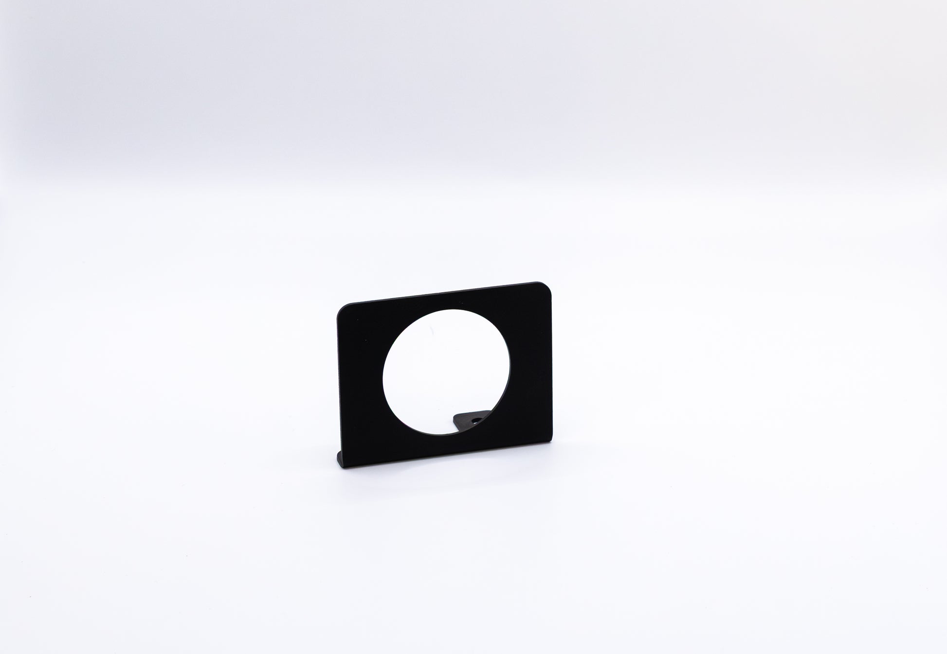 The Gauge Mount Sidekick Accessory by StayFlush Motorsports is a black, rectangular mount with a large circular cutout, shown upright against a plain white background.